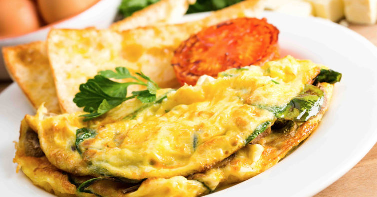 Omelete recheada com queijo, espinafres e tomate cherry